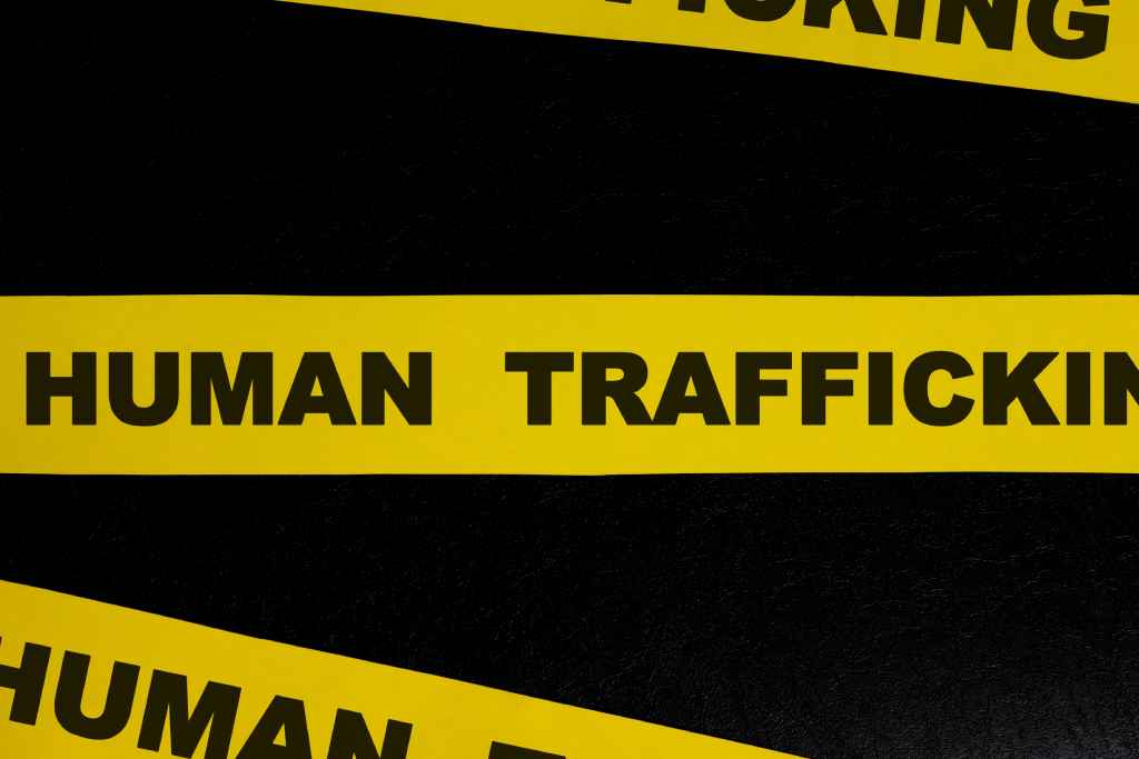 Human trafficking yellow caution tape across a black background